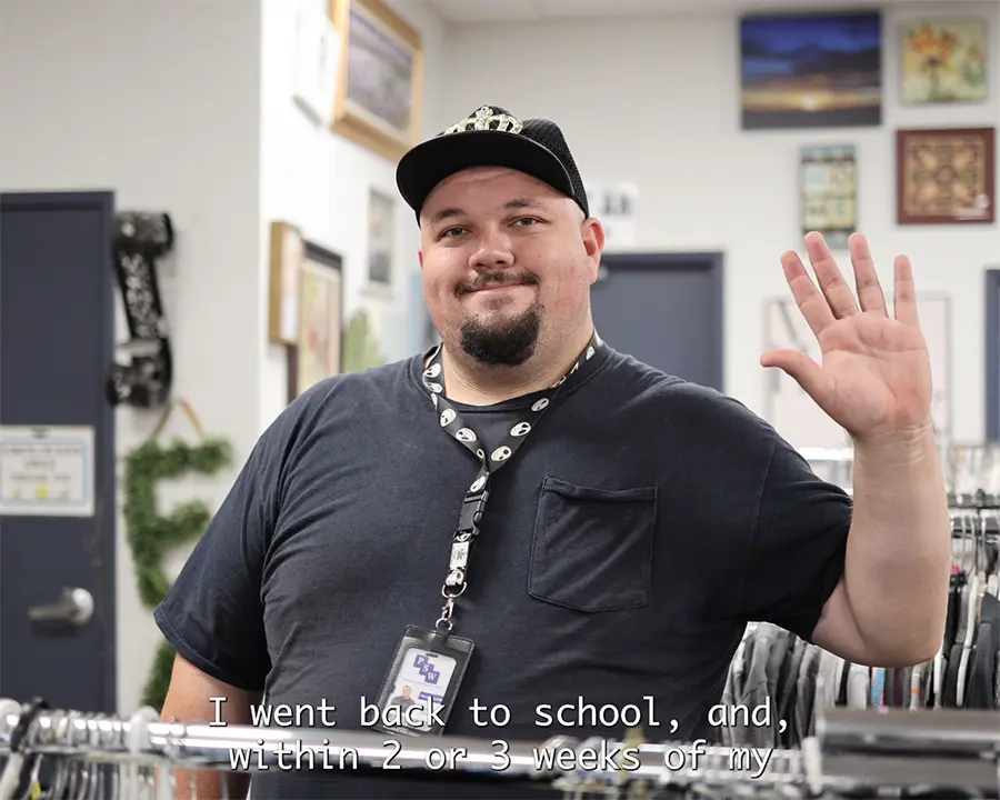 Photo of an individual smiling and waving at the Value Village Thrift Store